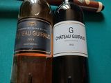 deux bouteilles de vin et un cigare posés sur une table de billard