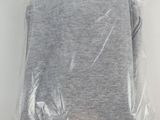 grey t - shirt wrapped in plastic on white background