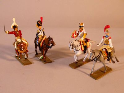 quatre figurines de soldats à cheval posées sur une surface blanche