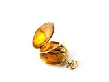 a small gold pocket watch with a chain on a white surface