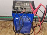 une boîte bleue sur laquelle se trouvent une batterie et un chargeur rouge et noir