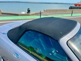 une voiture argentée au toit noir garée sur le bord de la route