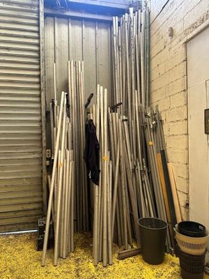 a pile of metal pipes in a room with a door