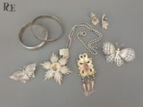 Plusieurs types de bijoux sont présentés sur un fond gris