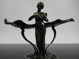 une photo en noir et blanc représentant la statue d'une femme tenant une fleur