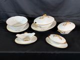 a set of six white and gold china dishes and saucers