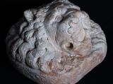 une image représentant une sculpture en pierre représentant un visage sur fond noir