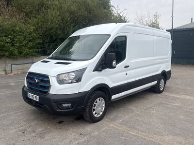 la camionnette blanche est garée sur un parking avec des arbres en arrière-plan