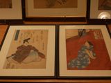 two framed asian paintings on a table in a room