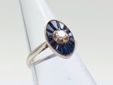un gros plan d'une bague ornée d'une fleur bleue