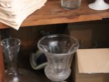 a wooden cabinet with a bunch of dishes and glasses on it