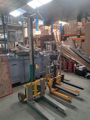 un chariot élévateur dans un entrepôt, avec de nombreux cartons en arrière-plan