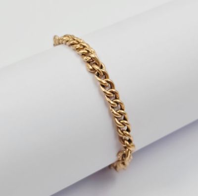 un gros plan d'un bracelet en or posé sur une serviette