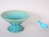 a small toy horse standing next to a blue bowl