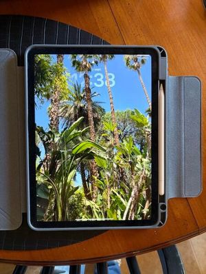 une photo d'une tablette posée sur une table, à côté d'une tasse de café
