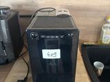 a black coffee machine sitting on a counter next to a sink