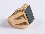 an image of a gold ring with a black stone in it
