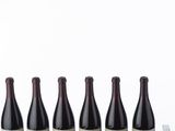 four bottles of wine are lined up on a table
