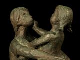 a statue of a man and a woman sitting on a rock
