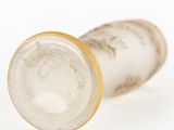 an old glass vase with a gold rim on a white surface