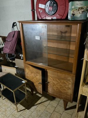 un meuble en bois avec une porte en verre au milieu d'une pièce