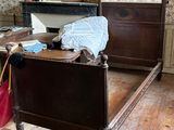 une chambre avec un lit, une commode, un miroir et une valise