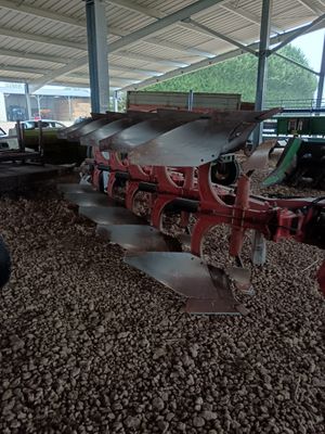 un homme debout à côté d'un tracteur équipé d'une charrue