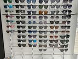 de nombreux modèles de lunettes de soleil de différentes teintes exposés dans un magasin