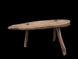une petite table en bois à deux pieds sur fond noir