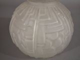 a white vase that has a maze design on it