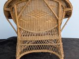 an image of a wicker chair sitting on top of a black carpet