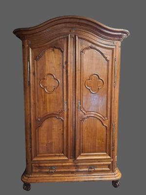 une armoire ancienne en bois, avec un dessus sculpté et deux portes