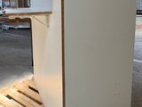 a white refrigerator sitting on a pallet in a warehouse