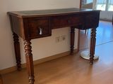 une table en bois avec un plateau en verre, dans un coin de la pièce