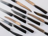 a lot of knives that are on a white surface