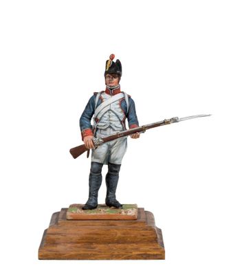 a statue of a man in uniform holding a rifle on a wooden base