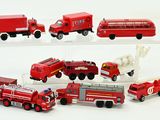 several toy fire trucks and trucks are lined up on a white surface
