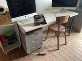 a desk with two monitors and a chair in front of it