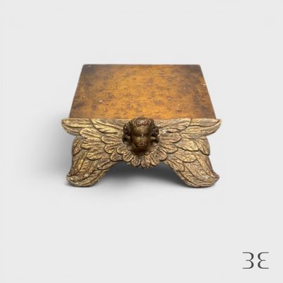 une petite boîte en or ornée d'une tête ailée