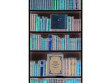 a book shelf filled with lots of books on top of it