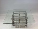 une photo d'une table basse en verre et en métal, dotée d'un plateau carré en verre