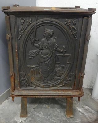 une vieille armoire en bois ornée d'une sculpture représentant une femme tenant un panier