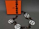 une boîte orange contenant un collier noir et blanc et un bracelet noir et blanc