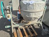 a cement mixer sitting on a pallet in a parking lot