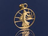 un gros plan sur un pendentif plaqué or représentant une femme à l'intérieur d'un cercle