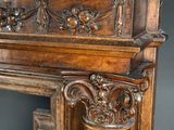 a wooden fireplace mantle with carvings on top of it