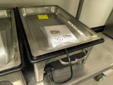 two trays of food sitting on a metal table