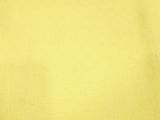 a piece of yellow fabric on a table next to a cup of coffee