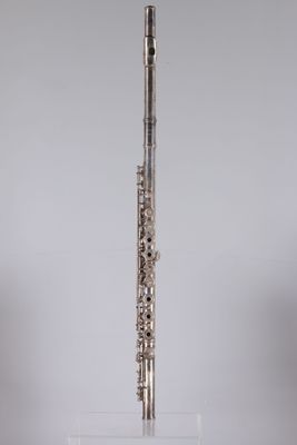 a silver flute on a clear stand against a white background