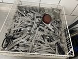 un panier rempli de fourchettes et de cuillères posé par terre